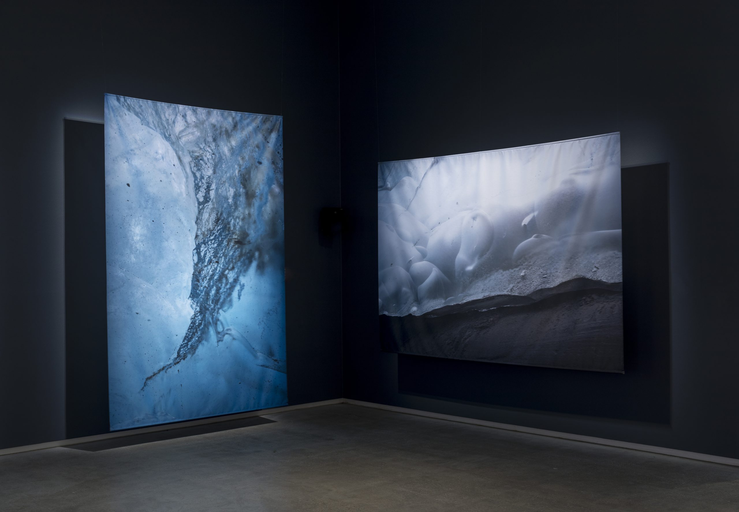 An art installation of two large blue glacier prints